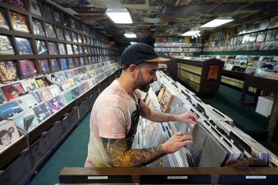 Jeff Maimon, of Chicago, checks out some vinyl at Tracks In Wax record shop, Thursday, April 18, 2024, in Phoenix. Special LP releases, live performances and at least one giant block party are scheduled around the U.S. Saturday as hundreds of shops celebrate Record Store Day amid a surge of interest in vinyl and the day after the release of Taylor Swift's latest album. (AP Photo/Ross D. Franklin)