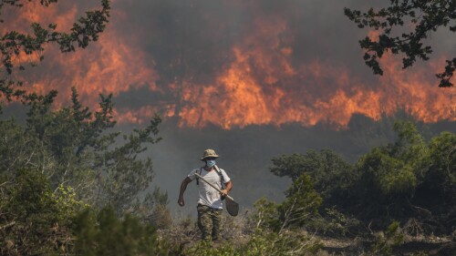 Flames burn a forest in Vati village, on the Aegean Sea island of Rhodes, southeastern Greece, on Tuesday, July 25, 2023. A third successive heat wave in Greece pushed temperatures back above 40 degrees Celsius (104 degrees Fahrenheit) across parts of the country Tuesday following more nighttime evacuations from fires that have raged out of control for days. (AP Photo/Petros Giannakouris)