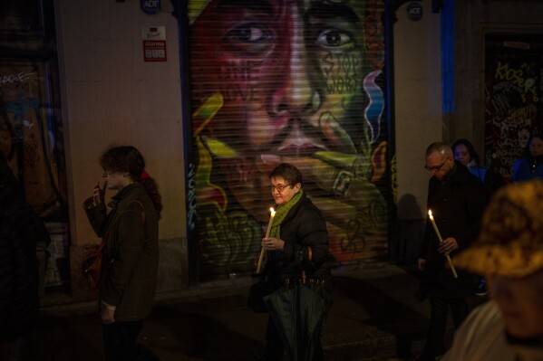 Worshippers hold candles during a procession asking for rain through the streets of downtown Barcelona, Spain, Saturday, March 9, 2024. A religious procession organised by the Brotherhoods of the Archdiocese of Barcelona marched through the city downtown asking for rain coinciding with just the rainiest day of the year. Spain's northeastern region of Catalonia declared a drought emergency for the area of around 6 million people including the city of Barcelona. (AP Photo/Emilio Morenatti)