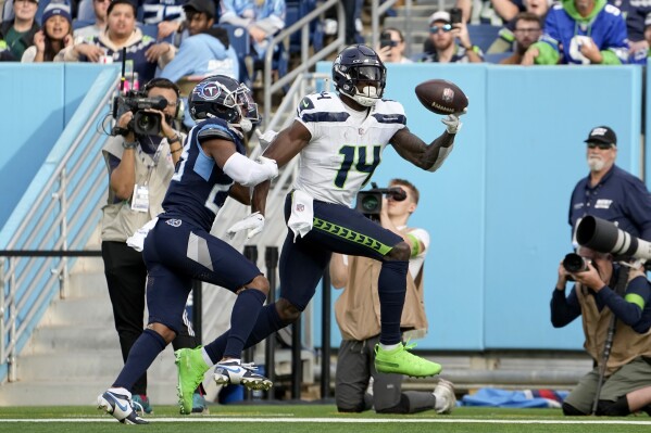 Seattle Seahawks wide receiver DK Metcalf (14) catches a touchdown pass in front of Tennessee Titans cornerback Tre Avery during the second half of an NFL football game on Sunday, Dec. 24, 2023, in Nashville, Tenn. (AP Photo/George Walker IV)