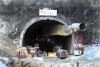 People stand near the entrance to the site of an under-construction road tunnel that collapsed in mountainous Uttarakhand state, India, Friday, Nov. 17, 2023. Rescuers drilled deeper into the rubble of a collapsed road tunnel in northern India on Friday to fix wide pipes for 40 workers trapped underground for a sixth day to crawl to their freedom. (AP Photo)