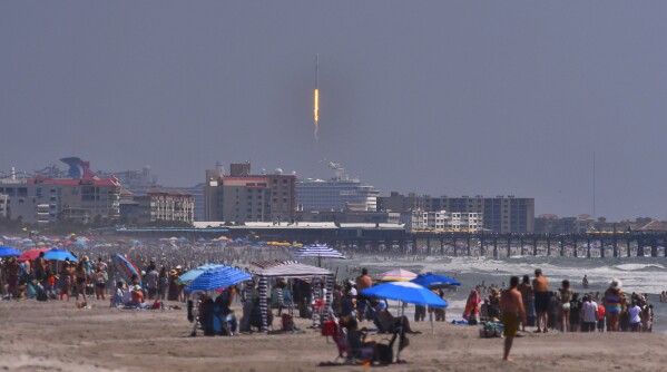 Crowds on the beach in Cocoa Beach, Fla., watch the launch of a SpaceX Falcon 9 rocket for the European Space Agency with the Euclid space telescope on Saturday, July 1, 2023. The European space telescope blasted off from Cape Canaveral Space Force Station, Saturday on a quest to explore the mysterious and invisible realm known as the dark universe. (Malcolm Denemark/Florida Today via AP)