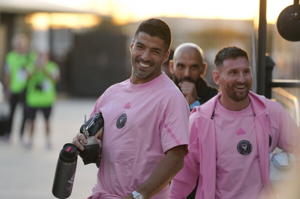 Inter Miami forwards Luis Suarez, left, and Lionel Messi, right, arrive for a friendly soccer match against Newell's Old Boys, Thursday, Feb. 15, 2024, in Fort Lauderdale, Fla. (AP Photo/Rebecca Blackwell)