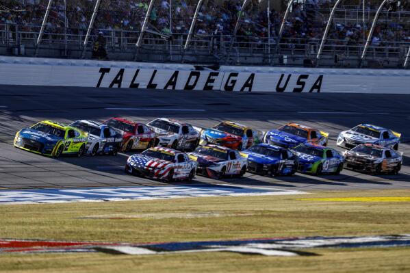 Ryan Blaney (12) leads the field through the tri-oval during a NASCAR Cup Series auto race Sunday, Oct. 2, 2022, in Talladega, Ala. (AP Photo/Butch Dill)