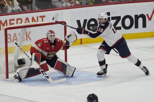 Columbus Blue Jackets left wing Dmitri Voronkov (10) hits the puck as Florida Panthers goaltender Sergei Bobrovsky (72) protects the net during the second period of an NHL hockey game, Thursday, April 11, 2024, in Sunrise, Fla. (AP Photo/Marta Lavandier)