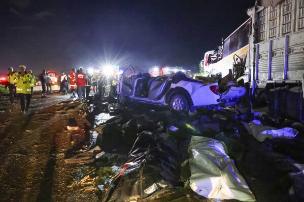Emergency rescue teams and police officers work on the aftermath of a multi vehicle crash accident near Mersin, southern Turkey, Sunday, May 26, 2024. A passenger bus has crashed into vehicles on a highway in southern Turkey, killing at least 10 people and leaving 39 others injured. The accident occurred in the province of Mersin late on Sunday, when the bus veered into the opposite lane in heavy rain and crashed into two vehicles. (IHA via AP)