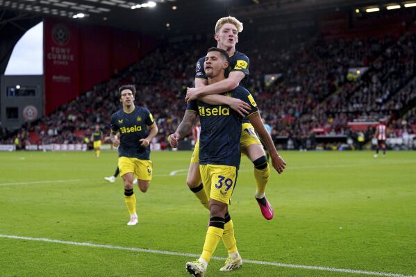 Newcastle United's Bruno Guimaraes celebrates with teammate Anthony Gordon after scoring his side's seventh goal of the game, during the English Premier League soccer match between Sheffield United and Newcastle United, at Bramall Lane, in Sheffield, England, Sunday, Sept. 24, 2023. (Martin Rickett/PA via AP)