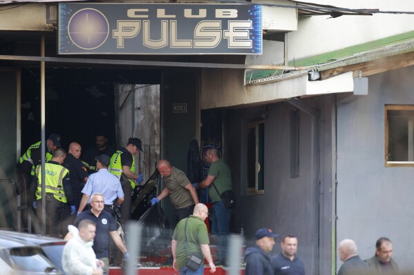 Police officers hold plastic bags on the site of a nightclub in the town of Kocani, North Macedonia, Sunday, March 16, 2025, following a massive fire in the nightclub early Sunday. (AP Photo/Visar Kryeziu)