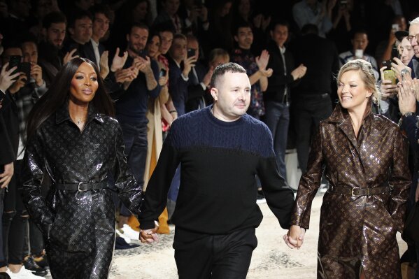 FILE - In this Jan.18, 2018 file photo, designer Kim Jones, centre, accepts applause as he walks with models Kate Moss, right, and Naomi Campbell after his Louis Vuitton men's Fall-Winter 2018/2019 fashion collection presented in Paris. Rome fashion house Fendi announced Wednesday, Sept. 9, 2020 that Kim Jones is taking over from the late Karl Lagerfeld as creative director of haute couture, ready-to-wear and fur collections. Jones will take on the Fendi duties while staying on as artistic director of Dior Homme. (AP Photo/Francois Mori)