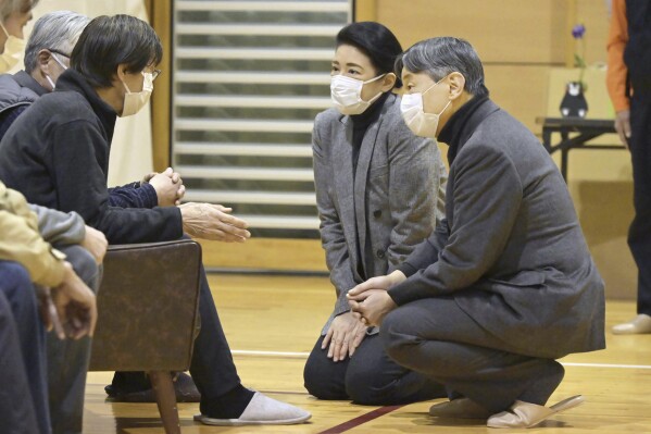 Japanese Emperor Naruhito, right, and Empress Masako visit the victims of the deadly Jan. 1 earthquakes, at a junior high school in Suzu, Ishikawa prefecture, Japan Friday, March 22, 2024. (Kyodo News via AP)