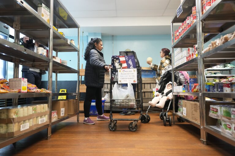 Betsy Quiroa, left, shops at a market-style food pantry at the Carver Center in Port Chester, N.Y., Wednesday, Nov. 15, 2023. A growing number of states are working to keep food out of landfills over concerns that it is taking up too much space and posing environmental problems. Some states including New York are requiring supermarkets and other businesses to redirect food to food pantries. (AP Photo/Seth Wenig)