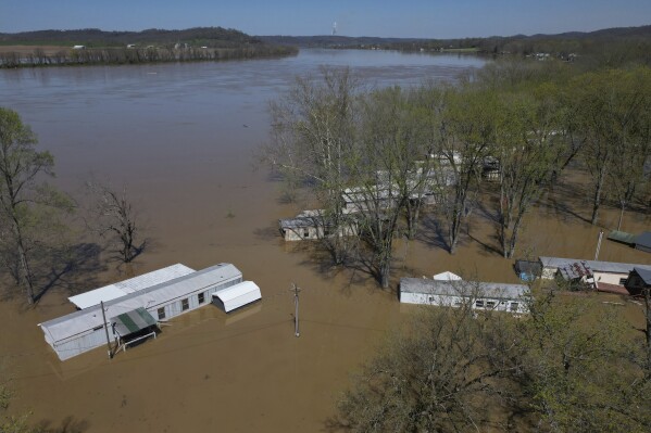 A mobile home park floods where rising waters of the Little Sugar Creek meet the Ohio River, Monday, April 7, 2025, in Napoleon, Ky. (AP Photo/Carolyn Kaster)