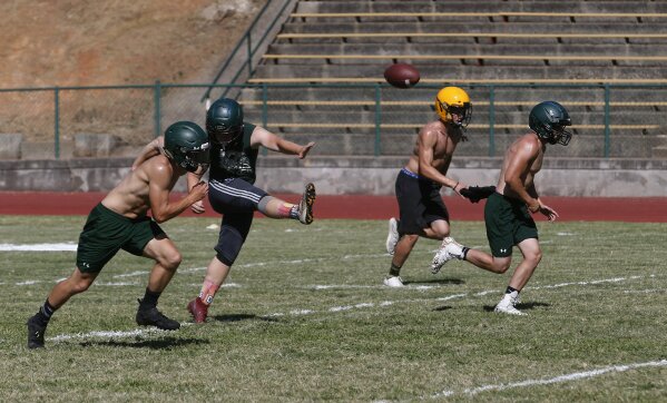 In this Thursday, Aug. 22, 2019, photo, the Paradise High School football team practices kickoffs in preparation for the teams first game of the season in Paradise, Calif. Paradise’s game against Williams High School on Friday will be the first game for the team since a wildfire nearly destroyed the foothill community last year. (AP Photo/Rich Pedroncelli)