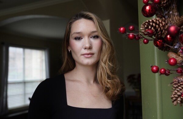 Nicole Plauché, 23, poses for a photo at her family's home in Highland Village, Texas, Friday, Dec. 15, 2023. Plauché graduated from college last year with a business degree and is navigating how to manage holiday spending while paying student loan debt. (AP Photo/LM Otero)