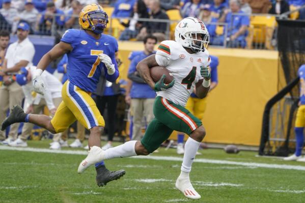 Miami running back Jaylan Knighton (4) runs past Pittsburgh linebacker SirVocea Dennis (7) on his way to a long touchdown run during the first half of an NCAA college football game, Saturday, Oct. 30, 2021, in Pittsburgh. (AP Photo/Keith Srakocic)