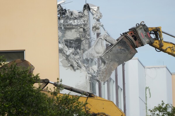 Crews start the demolition of the Marjory Stoneman Douglas High School building, Friday, June 14, 2024, where 17 people died in the 2018 mass shooting in Parkland, Fla. Officials plan to complete the weekslong project before the school's 3,300 students return in August from summer vacation. (AP Photo/Wilfredo Lee)