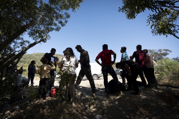 Border Patrol agents talk with migrants seeking asylum as they prepare them for transportation to be processed Wednesday June 5 2024 near Dulzura Calif President Joe Biden on Tuesday unveiled plans to enact immediate significant restrictions on migrants seeking asylum at the US-Mexico border as the White House tries to neutralize immigration as a political liability ahead of the November elections AP PhotoGregory Bull