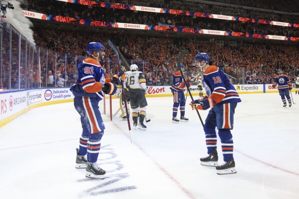 Edmonton Oilers' Evander Kane (91) and Zach Hyman (18) celebrate after a goal against the Vegas Golden Knights during the second period of Game 4 of a second-round NHL hockey playoff series in Edmonton, Alberta, Monday, May 12, 2025. (Jason Franson/The Canadian Press via AP)