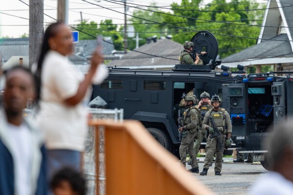 Residents watch as law enforcement search for a fugitive that escaped a prison in New Orleans, Wednesday, May 21, 2025. (Chris Granger/The Times-Picayune/The New Orleans Advocate via AP)