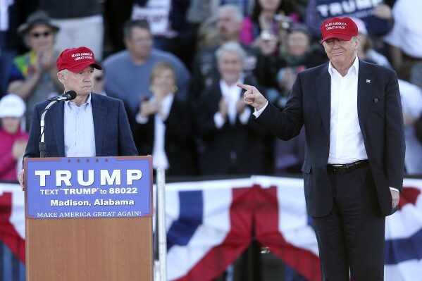 FILE - Republican presidential candidate Donald Trump, right, gestures as Sen. Jeff Sessions, R-Ala., speaks during a rally, Feb. 28, 2016, in Madison, Ala. Republican presidential candidates will gather in Alabama on Wednesday, Dec. 6, 2023, for the fourth GOP debate of the 2024 presidential campaign. Former President Trump will skip the debate as he maintains his wide lead over his rivals. But the setting in Alabama helps explain why the former president has such a grip on Republican politics in 2024. (AP Photo/John Bazemore, File)