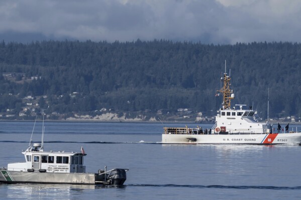FILE - A U.S. Coast Guard boat and Kitsap, Wash., County Sheriff boat search an area, Monday, Sept. 5, 2022, near Freeland, Wash., on Whidbey Island north of Seattle where a chartered floatplane crashed the day before, killing 10 people. On Thursday, Oct. 5, 2023, the National Transportation Safety Board confirmed that a mechanical issue caused the seaplane to crash. (AP Photo/Stephen Brashear, File)