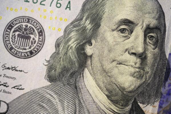 The likeness of Benjamin Franklin is seen on a U.S. $100 bill, Wednesday, Feb. 22, 2023, in Marple Township, Pa. If you are concerned you may be laid off, start saving. It's crucial to start building an emergency fund even when you feel secure at your job but especially if you think you might lose it. (AP Photo/Matt Slocum)