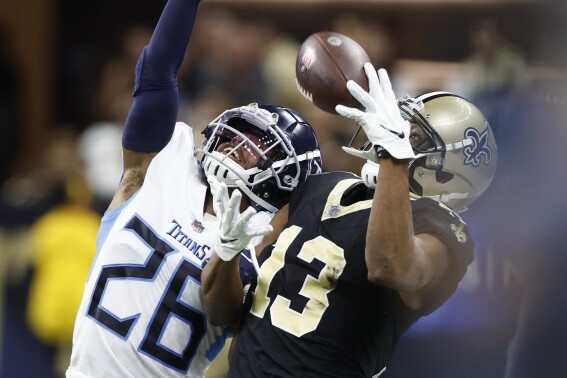 New Orleans Saints wide receiver Michael Thomas (13) makes a catch past Tennessee Titans cornerback Kristian Fulton (26) in the first half of an NFL football game in New Orleans, Sunday, Sept. 10, 2023. (AP Photo/Butch Dill)