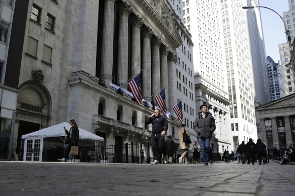 FILE - People pass the front of the New York Stock Exchange in New York, March 21, 2023. Wall Street is retreating a bit more as a five-week rally loses momentum. (AP Photo/Peter Morgan, File)