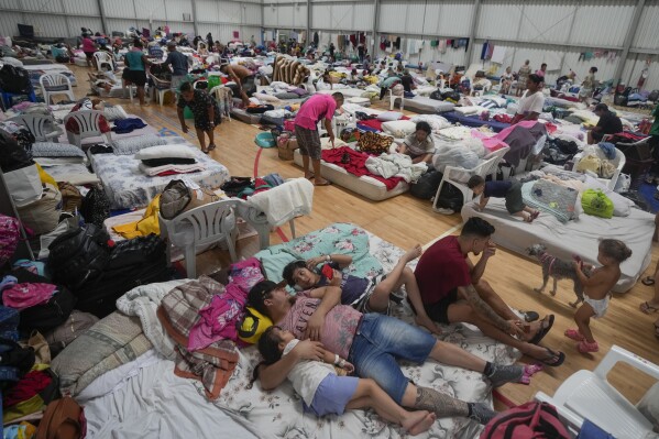 Residents rest in a makeshift shelter for people whose homes were flooded by heavy rains, in Canoas, Rio Grande do Sul state, Brazil, Wednesday, May 8, 2024. (AP Photo/Carlos Macedo)