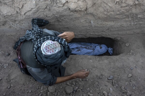 An Afghan man buries his little grandson who was killed by the earthquake, in Zenda Jan district in Herat province, western of Afghanistan, Monday, Oct. 9, 2023. Saturday's deadly earthquake killed and injured thousands when it leveled an untold number of homes in Herat province. (AP Photo/Ebrahim Noroozi)