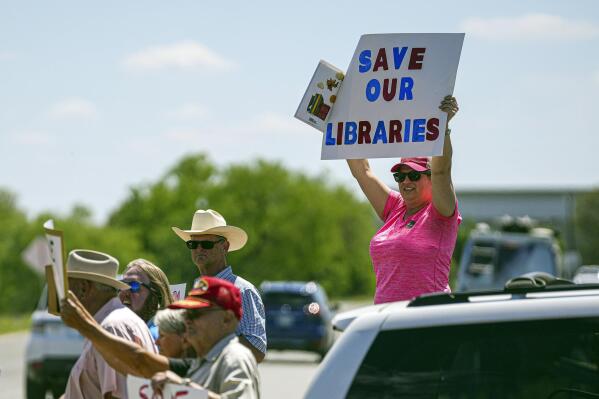 Llano resident Emily Decker protests outside a Llano County Commissioner's Court meeting at the Llano County Law Enforcement Center on Thursday, April 13, 2023 in Llano, Texas. Leaders in a rural Texas county held a special meeting Thursday but drew back from considering shutting their public library system rather than follow a federal judge's order to return books to the shelves on themes ranging from teen sexuality to bigotry. (Aaron E. Martinez/Austin American-Statesman via AP)