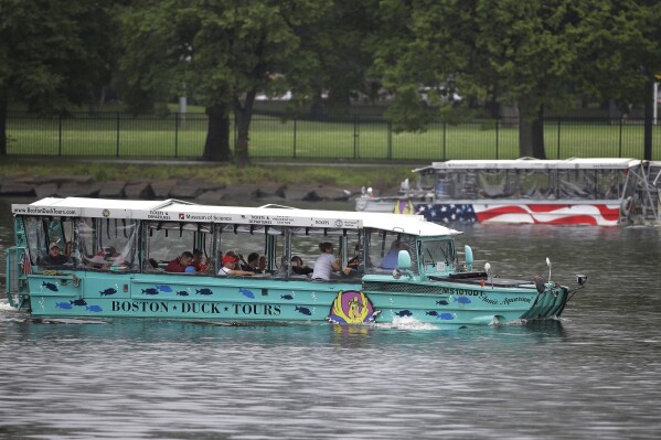 FILE - Duck boats, replicas of World War II-era amphibious vehicles, and a popular tourist attraction, make their way along the Charles River between Boston and Cambridge, Mass., Sunday, July 22, 2018. Five years after 17 people died when a tourist vessel known as a duck boat sank on a Missouri lake, the U.S. Coast Guard on Monday, Sept. 11, 2023 issued new rules for amphibious World War II vessels retrofitted for tourists. (AP Photo/Steven Senne, File)