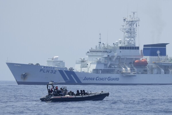 FILE - A Philippine Coast Guard rigid hull inflatable boat passes by the Japanese Coast Guard Akitsushima (PLH-32) during a trilateral Coast Guard drill of the U.S., Japan and Philippines, near the waters of the disputed South China See in Bataan province, Philippines, Tuesday, June 6, 2023. The United States, Japan and Australia are planning a joint navy drill in the South China Sea off the western Philippines this week to underscore their commitment to the rule of law in the region after a recent show of Chinese aggression in the disputed waters, Filipino security officials said Sunday, Aug. 20, 2023. (AP Photo/Aaron Favila, File)