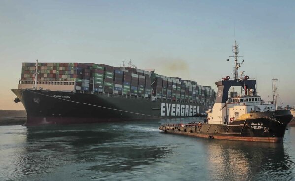 In this photo released by Suez Canal Authority, the Ever Given, a Panama-flagged cargo ship, is pulled by one of the Suez Canal tugboats, in the Suez Canal, Egypt, Monday, March 29, 2021. Engineers on Monday "partially refloated " the colossal container ship that continues to block traffic through the Suez Canal, authorities said, without providing further details about when the vessel would be set free. (Suez Canal Authority via AP)