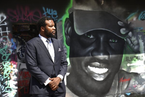Lee Merritt, a lawyer representing the family of Ahmaud Arbery, poses for a photo by a mural in the likeness of Arbery painted by artist Theo Ponchaveli in Dallas, Saturday, May 9, 2020. Arbery’s mother, Wanda Cooper Jones, has said she thinks her son, a former high school football player, was jogging for exercise before he was killed on Feb. 23. After a video of the shooting emerged on social media, the Georgia Bureau of Investigation, on Wednesday, arrested Gregory McMichael, 64, and his son, Travis McMichael, 34, and they were jailed on murder and aggravated assault charges. (AP Photo/Tony Gutierrez)