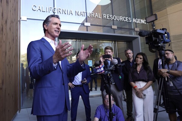 FILE - California Gov. Gavin Newsom speaks to reporters outside the California Natural Resources Agency in Sacramento, Calif., on Oct. 7, 2022. The state of California has filed a lawsuit against some of the world's largest oil and gas companies, claiming they deceived the public about the risks of fossil fuels blamed for climate change-related storms and wildfires that caused billions of dollars in damage. Newsom says Exxon Mobil, Shell, Chevron and others have lied about the danger of fossil fuels for years and taxpayers shouldn't have to pay for damages. (AP Photo/Rich Pedroncelli, File)