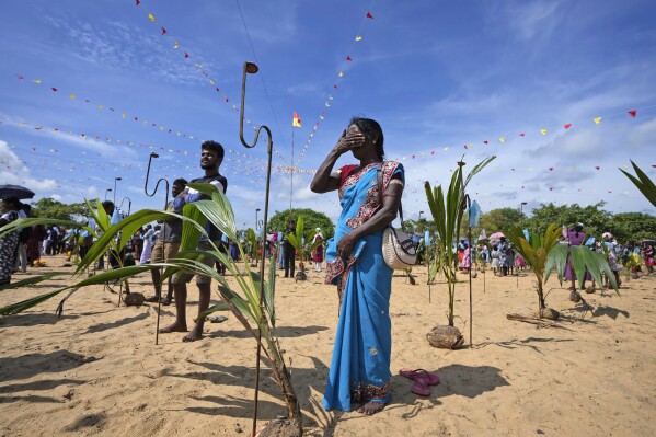 Sri Lankan Tamil war survivors perform rituals for their deceased family members during a remembrance ceremony on a small strip of land where thousands of civilians were trapped during the last stages of the country's civil war in Mullivaikkal, Sri Lanka, Saturday, May 17, 2024. Ethnic Tamils commemorated the 15th anniversary of the bloody end to Sri Lanka's civil war, lighting lamps and offering flowers at the site where thousands of people are said to have been killed and maimed in the final stages of the fighting. (AP Photo/Eranga Jayawardena)