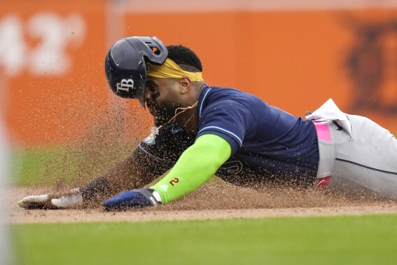 Tampa Bay Rays designated hitter Yandy Diaz starts sliding into third from first on a single by by Wander Franco during the sixth inning of a baseball game against the Detroit Tigers, Sunday, Aug. 6, 2023, in Detroit. (AP Photo/Carlos Osorio)