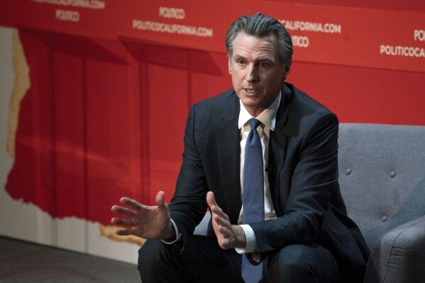 EMBARGOED HOLD FOR RELEASE - FILE - California Gov. Gavin Newsom speaks during an interview with Politico in Sacramento, Calif., Sept. 12, 2023. On Friday, Oct. 13, 2023, Newsom announced he signed a law that will increase the minimum wage for health care workers in the state. (AP Photo/Rich Pedroncelli, File)