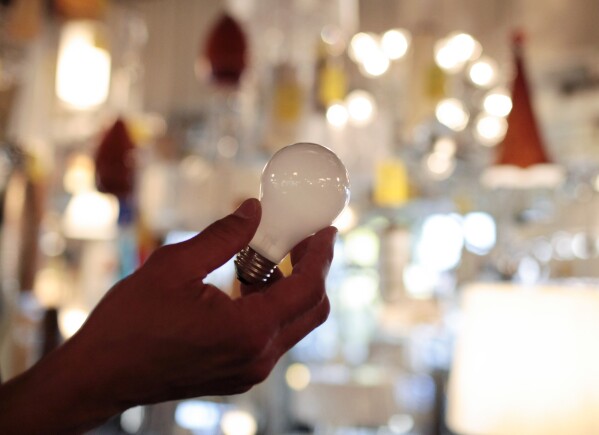 FILE - Manager Nick Reynoza holds a 100-watt incandescent light bulb at Royal Lighting in Los Angeles, Jan. 21, 2011. New federal rules governing the energy efficiency of lighting systems went into full effect Tuesday, effectively ending the sale and manufacture of bulbs that trace their origin to an 1880 Thomas Edison patent. (AP Photo/Jae C. Hong, File)