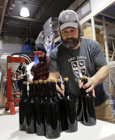 
              In this March 4, 2019, photo, brewery founder Jamie Adams, right, and John Condzella bottle a batch of their Dubbel beer at the St. James Brewery in Holbrook, N.Y. Adams recently introduced an ale called Deep Ascent at a New York craft beer festival after he created it, using the yeast from the bottles recovered from the SS Oregon, a Liverpool-to-New York luxury liner that sank off Fire Island in 1886. (AP Photo/Seth Wenig)
            