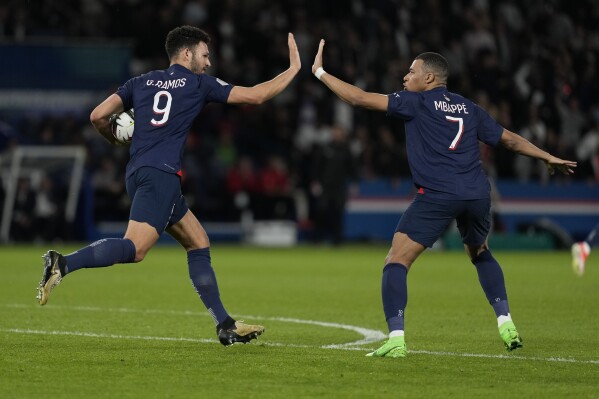 PSG's Goncalo Ramos, left, celebrates with teammate Kylian Mbappe scoring his side's first goal during the French League One soccer match between Paris Saint-Germain and Clermont at the Parc des Princes stadium in Paris, Saturday, April 6, 2024. (AP Photo/Lewis Joly)