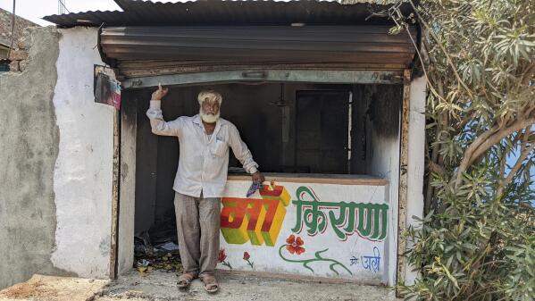 Nawab Khan stands by the entrance of his shop  vandalized by a mob on April 10 in Khargone, in the central Indian state of Madhya Pradesh, Tuesday, April 12, 2022. On April 10, a Hindu festival marking the birth anniversary of Lord Ram turned violent in Khargone after Hindu mobs brandishing swords and sticks marched past Muslim neighborhoods and mosques. Videos showed hundreds of them dancing and cheering in unison to songs blared from loudspeakers that included calls for violence against Muslims. (AP Photo/Kashif Kakvi)