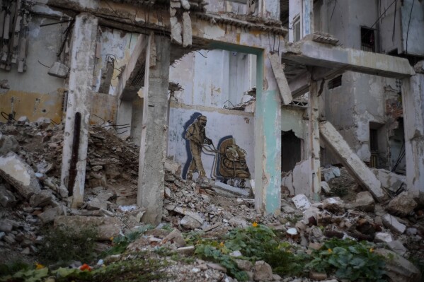 A mural decorates a wall inside a destroyed, abandoned building on San Lazaro street near the malecon seawall in downtown Havana, Cuba, Tuesday, Oct. 10, 2023. The housing situation in Cuba is critical, with buildings partially or completely collapsing under the weight of storms, lack of maintenance and years of neglect. (AP Photo/Ramon Espinosa)
