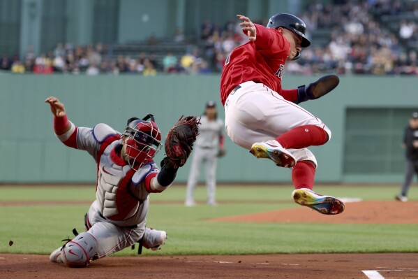 Boston Red Sox's Tyler O'Neill, right, is tagged out at the plate by Washington Nationals catcher Keibert Ruiz during the first inning of a baseball game Friday, May 10, 2024, in Boston. (AP Photo/Mark Stockwell)