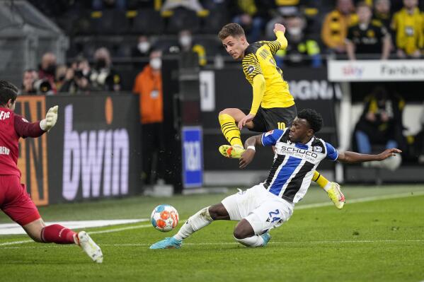 Dortmund's Thorgan Hazard, up, and Arminia's George Bello challenge for the ball during the German Bundesliga soccer match between Borussia Dortmund and Arminia Bielefeld in Dortmund, Germany, Sunday, March 13, 2022. (AP Photo/Martin Meissner)