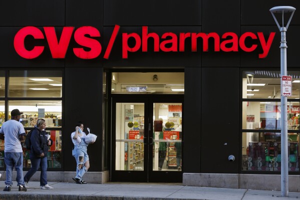 FILE - Customers walk to a CVS Pharmacy, Friday, Nov 4, 2022, in Boston. CVS made a move Wednesday, Sept. 27, 2023, to make frustrated pharmacists in the Kansas City-area to call off a walkout. It promised to boost hiring to ease overwhelming workloads that sometimes make it hard to take a bathroom break. (AP Photo/Michael Dwyer, FIle)
