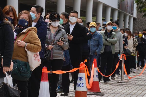 Residents line up to get tested for the coronavirus at a temporary testing center in Hong Kong Wednesday, Feb. 23, 2022. Hong Kong residents are becoming increasingly annoyed with the administration’s insistence on sticking to China's “zero-COVID” strategy as the city posted another record number of new cases Wednesday, bristling at ever-stricter regulations and a plan to test every city resident for the virus.   (AP Photo/Vincent Yu)