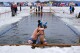Andie Nelson, right, embraces Brian Jaskot, both of Virginia, after their race during the 25 meter hat competition during the winter swimming festival on frozen Lake Memphremagog, Friday, Feb. 23, 2024, in Newport, Vermont. (AP Photo/Charles Krupa)