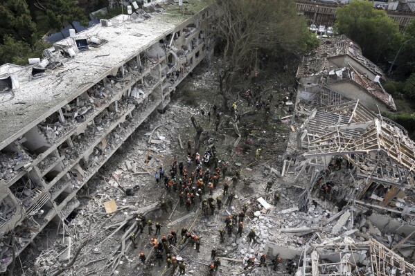 Rescue workers and firefighters survey the site of a direct missile strike launched from Iran in Tel Aviv, Israel, on Sunday, June 22, 2025. (AP Photo/Oded Balilty)